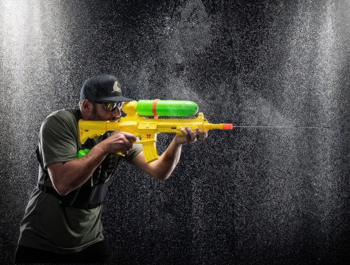 A man using a water gun like a real rifle